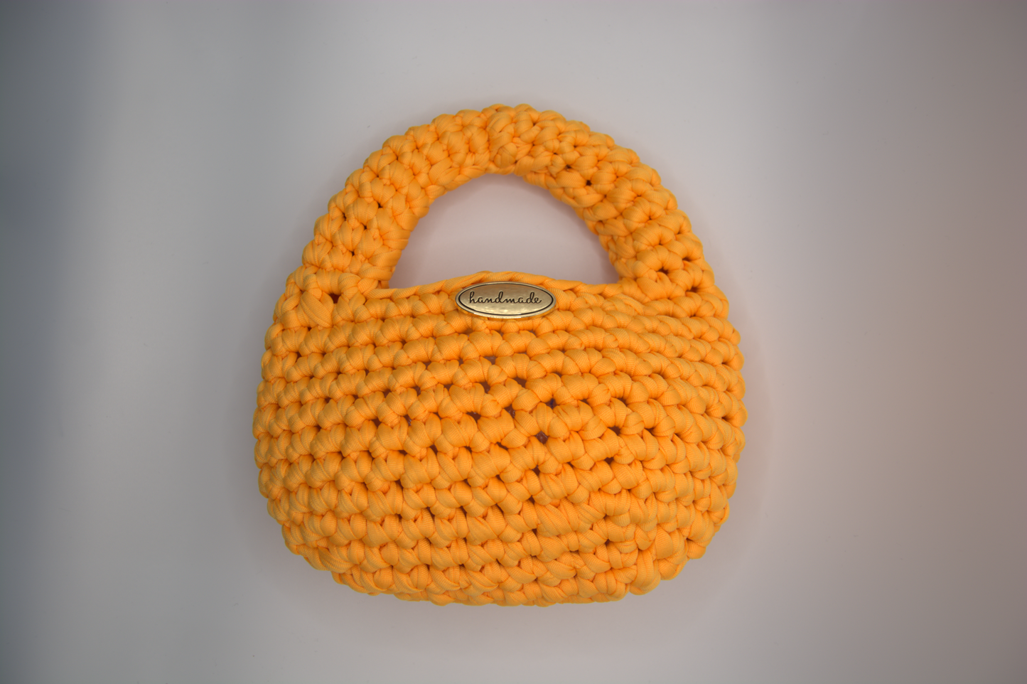 Mini bag arancio bruciato all'uncinetto mostrata piena