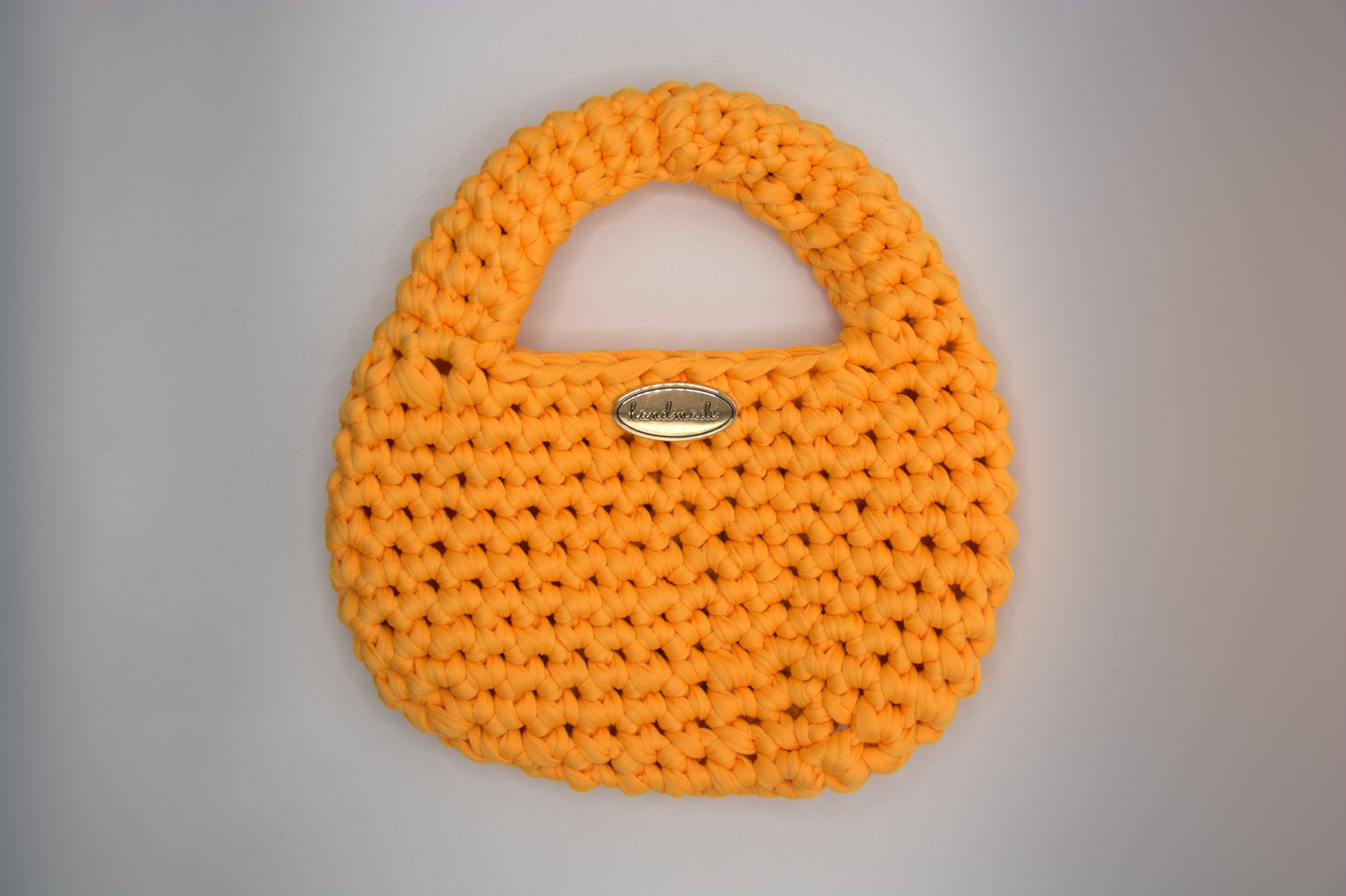 Mini bag arancio bruciato all'uncinetto mostrata vuota