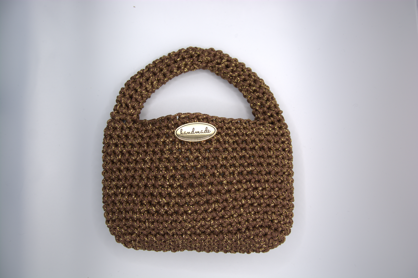 Dettaglio della lavorazione crochet e del manico della mini bag color cacao
