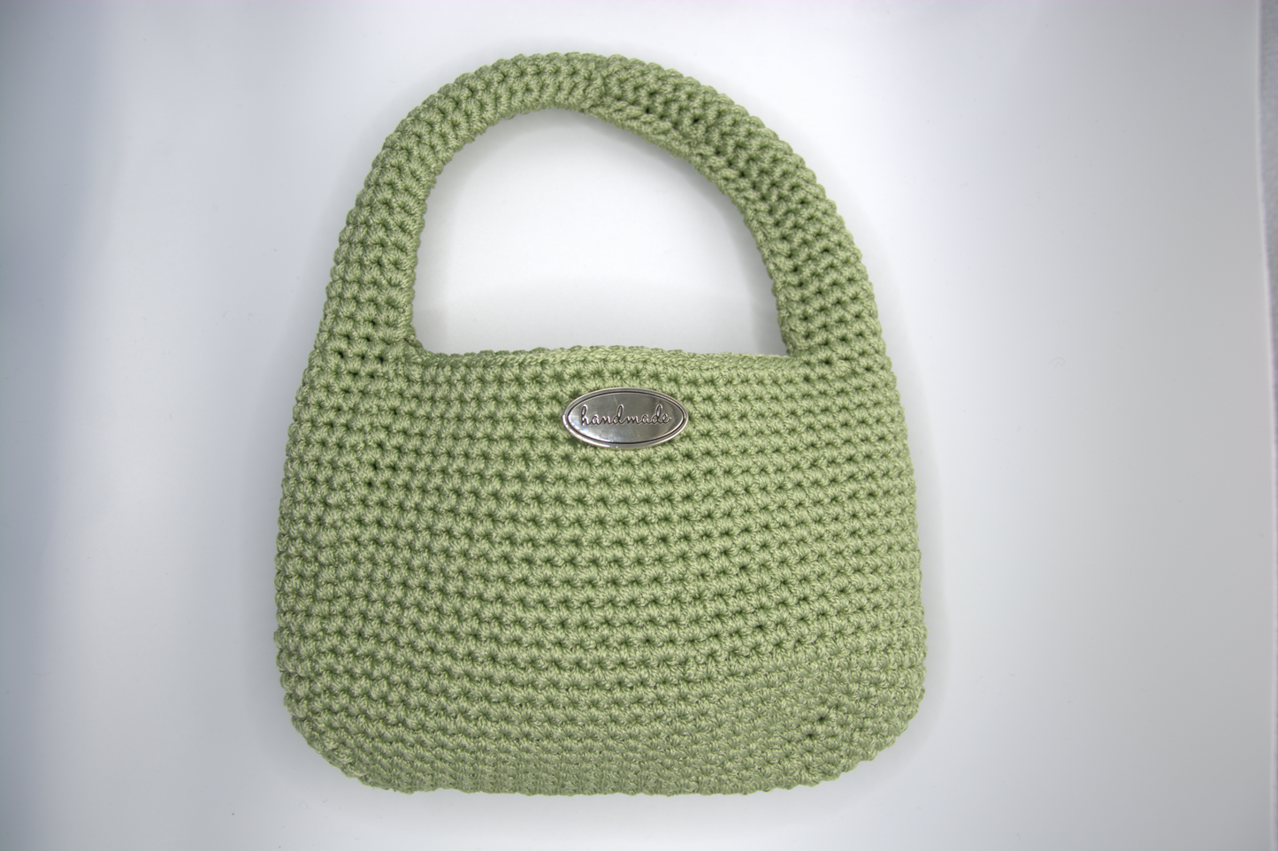 Dettaglio della lavorazione crochet e del manico della mini bag salvia