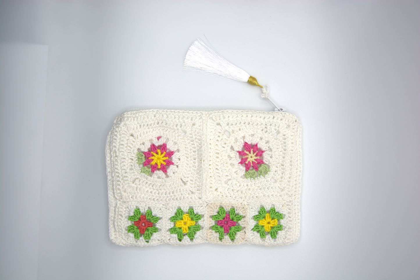Dettaglio dei motivi floreali della pochette bianco latte all'uncinetto