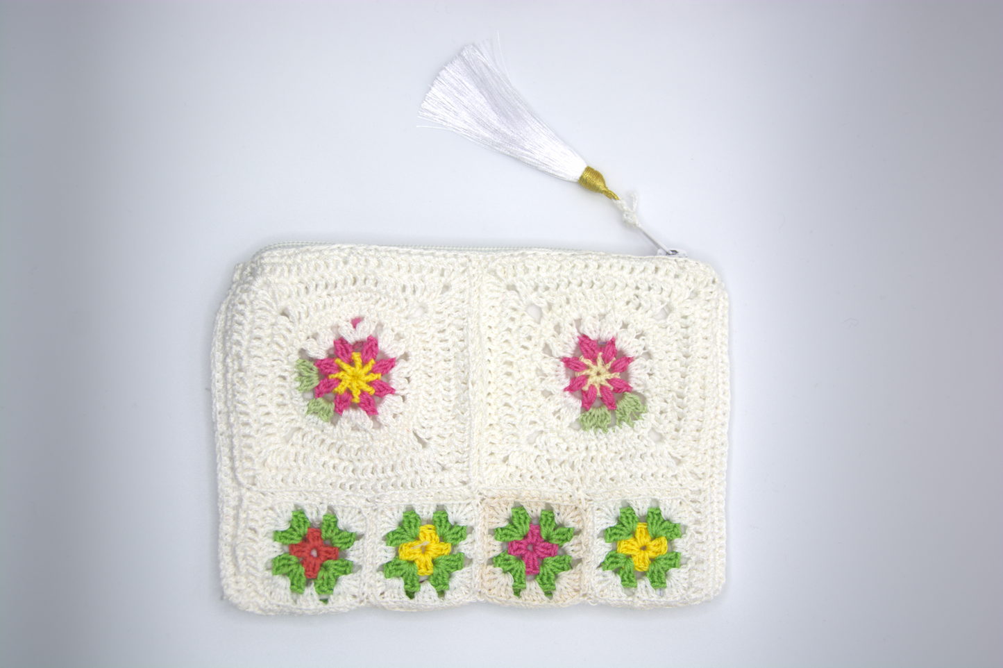 Pochette bianco latte all'uncinetto con motivi floreali granny e nappina