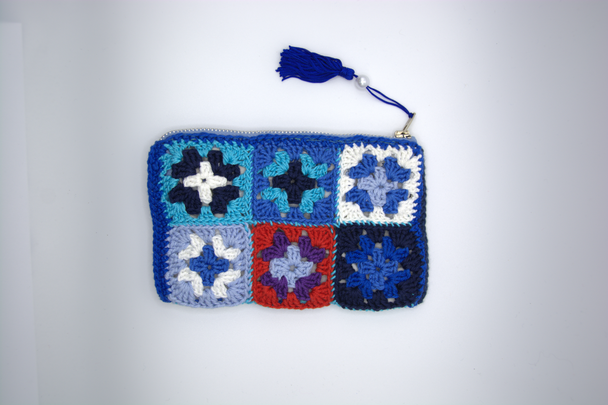 Dettaglio dei fiori granny della pochette blu notte all'uncinetto