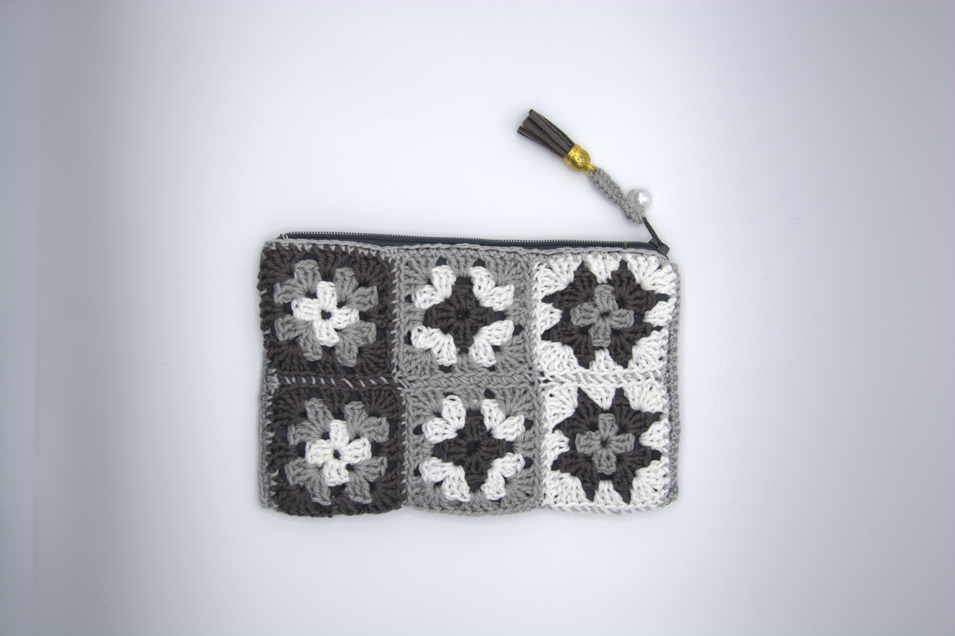 Pochette grigio perla e bianca all'uncinetto con fiori granny e nappina